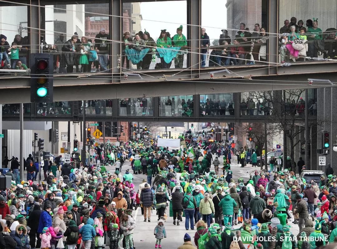 Crowds packed inside the elevated skyway and along the street below during the Saint Paul St. Patrick's Day Parade — three visible levels of people watching at once.