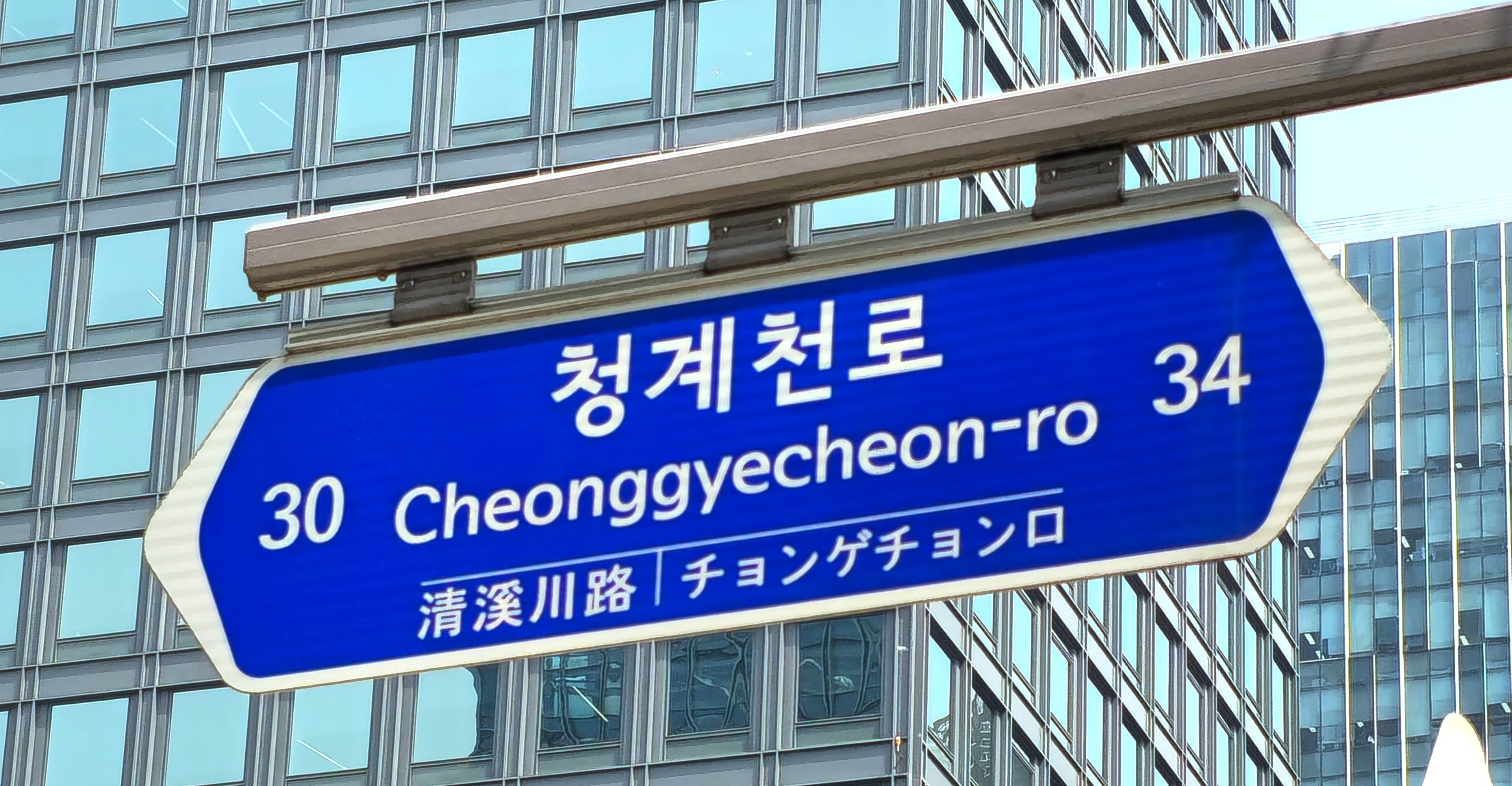 A street sign reading 'Cheonggyecheon-ro' — wayfinding for the corridor as a public place, not just a road.