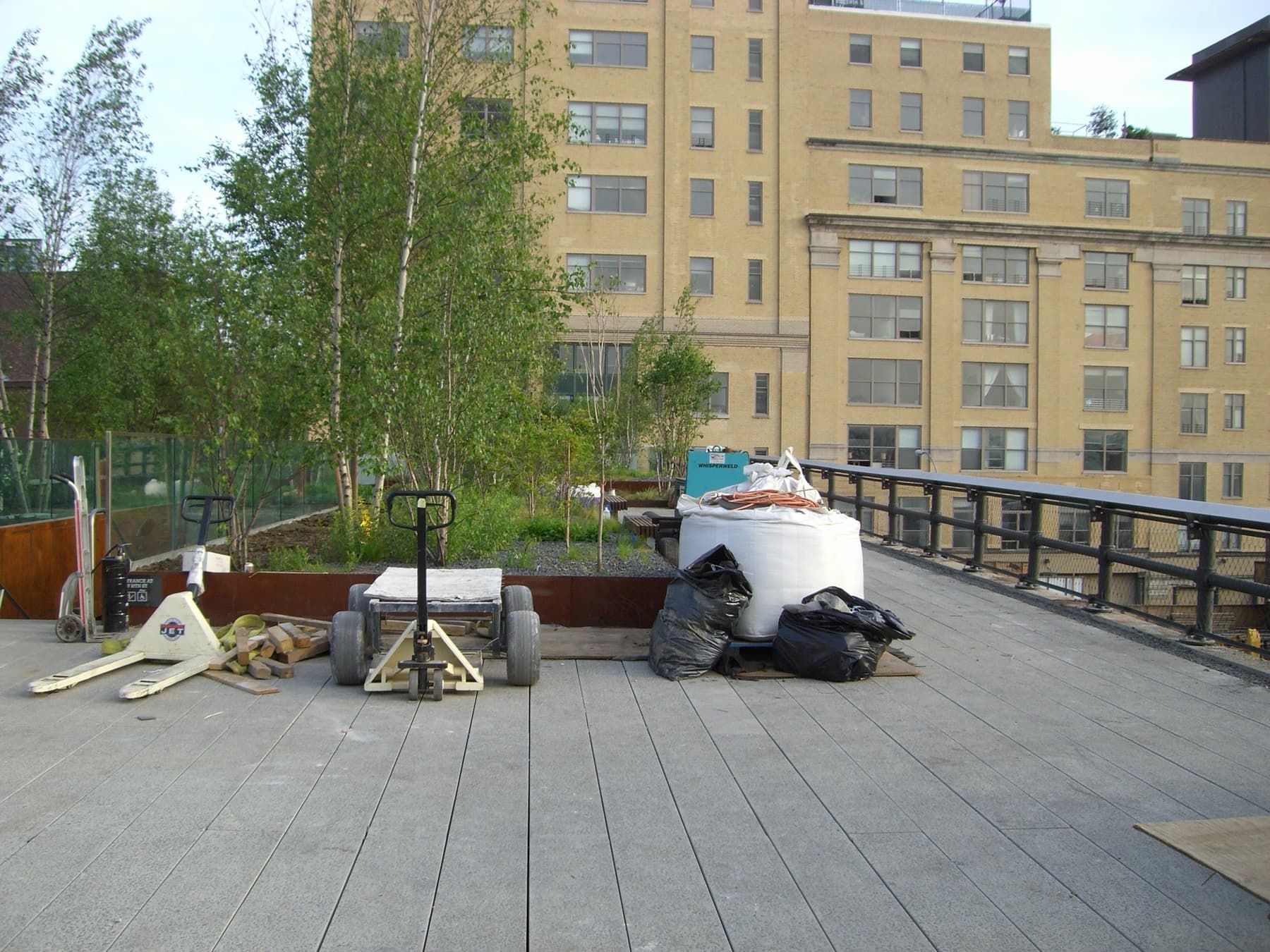 The High Line under construction in May 2009 — raw concrete pavers and newly set plantings on the viaduct, weeks before Section 1 opened that June.